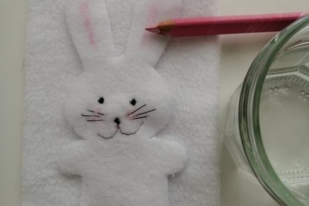 a white Fleece bunny with stitched face and pink ears