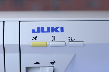 The thread trimmer button on the Juki NX7 sewing machine